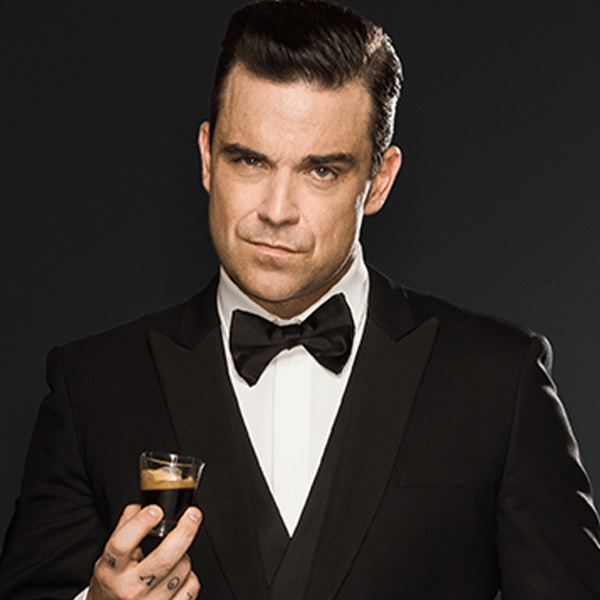 Robbie Williams holding an espresso cup