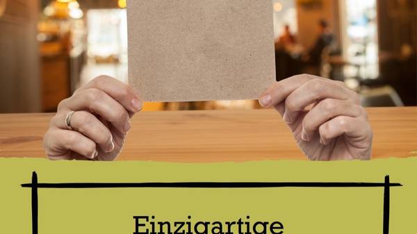 Hands holding a blank piece of card in front of a face, above a cropped German headline.