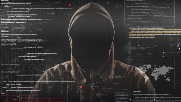 Hooded figure against a dark background of source code and a world map.