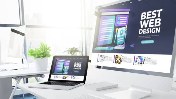 Monitor and laptop on a white desk showing the same website titled Best Web Design.
